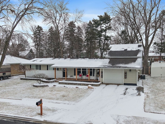 view of front of property featuring a porch, a garage, and central air condition unit