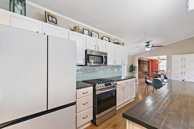 kitchen with appliances with stainless steel finishes, backsplash, ornamental molding, white cabinets, and light wood-type flooring