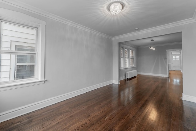 empty room featuring radiator heating unit, dark wood-type flooring, an inviting chandelier, and ornamental molding