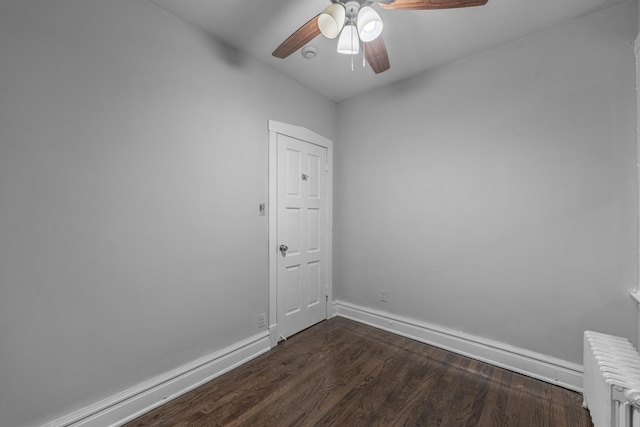 unfurnished room with dark hardwood / wood-style flooring, ceiling fan, and radiator heating unit