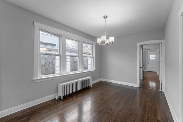 unfurnished dining area with a chandelier, dark hardwood / wood-style flooring, and radiator