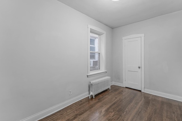 spare room featuring radiator heating unit, dark hardwood / wood-style flooring, and cooling unit