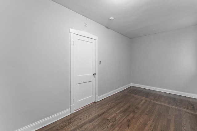 unfurnished room featuring dark wood-type flooring