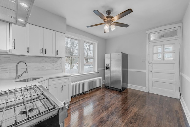 kitchen featuring ceiling fan, sink, stainless steel fridge with ice dispenser, radiator heating unit, and white cabinetry