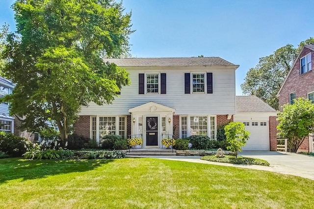 colonial-style house featuring a front yard and a garage