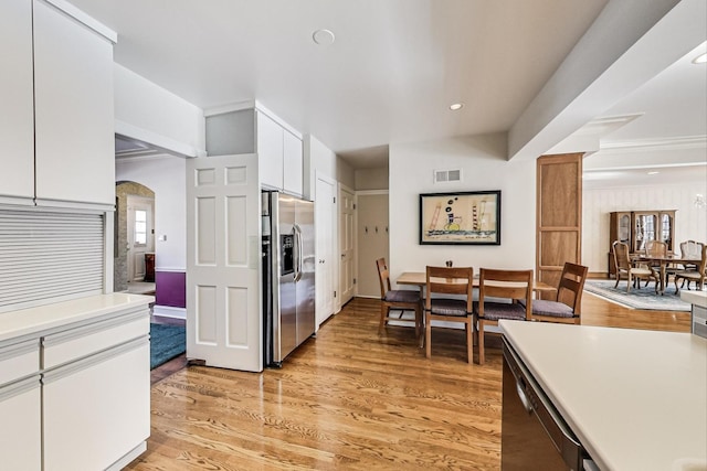 kitchen featuring dishwasher, light wood-type flooring, stainless steel fridge with ice dispenser, and white cabinetry