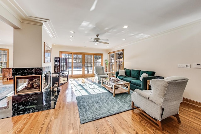 living room with wood-type flooring, ceiling fan, french doors, and crown molding