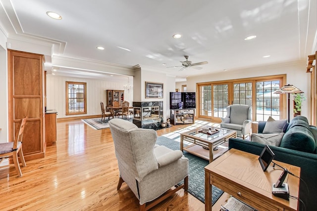 living room with ceiling fan, ornamental molding, and light hardwood / wood-style flooring