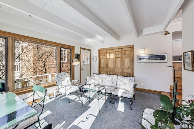 carpeted living room with beamed ceiling