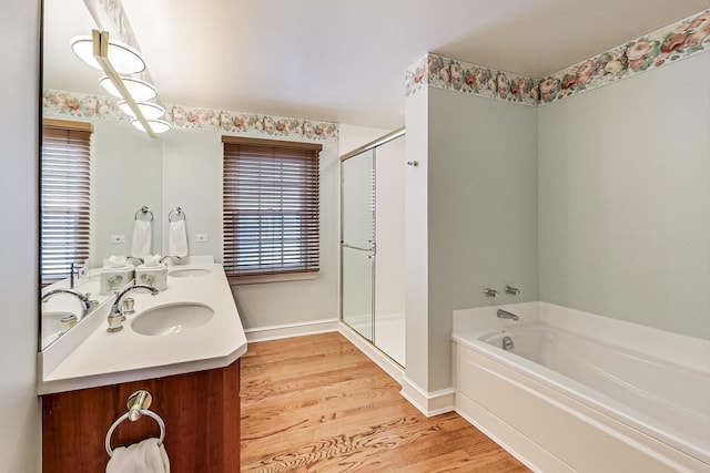 bathroom featuring hardwood / wood-style flooring, plus walk in shower, a wealth of natural light, and vanity