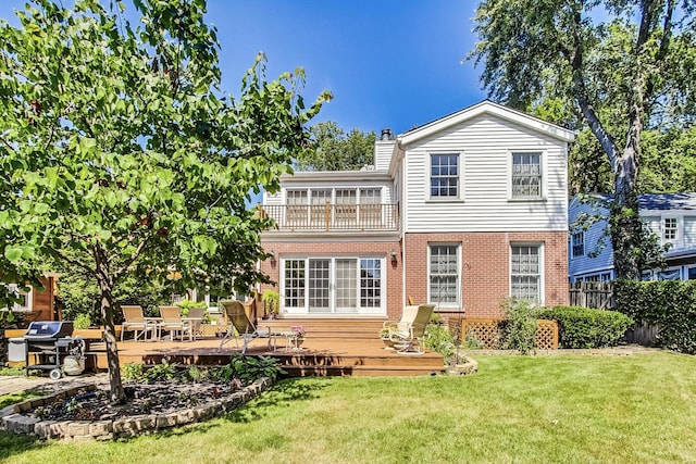 back of property with a balcony, a deck, and a yard