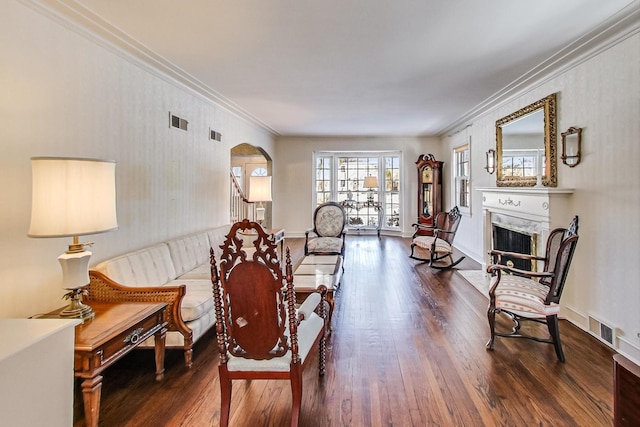 sitting room with crown molding and dark wood-type flooring