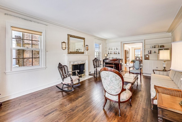 living room with a healthy amount of sunlight, dark hardwood / wood-style floors, built in shelves, and a fireplace