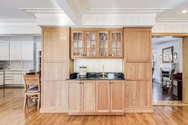 bar with light wood-type flooring, ornamental molding, dark stone countertops, and decorative backsplash