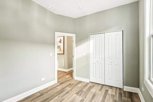 unfurnished bedroom with light hardwood / wood-style flooring and a closet