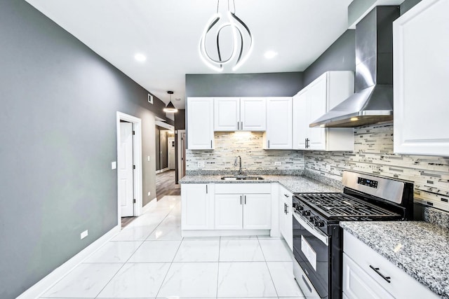 kitchen featuring gas stove, sink, wall chimney exhaust hood, hanging light fixtures, and white cabinets