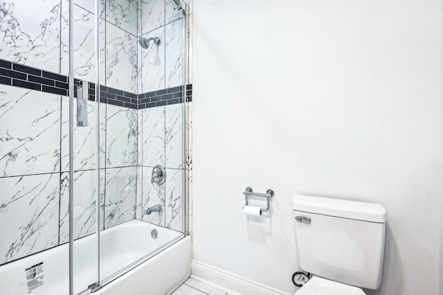 bathroom featuring toilet and bath / shower combo with glass door