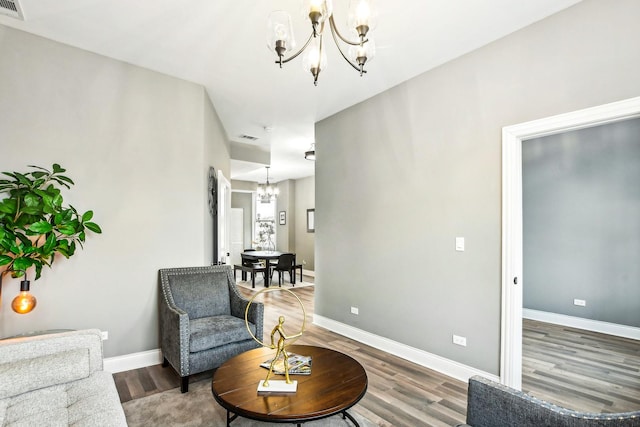 sitting room with a chandelier and hardwood / wood-style flooring