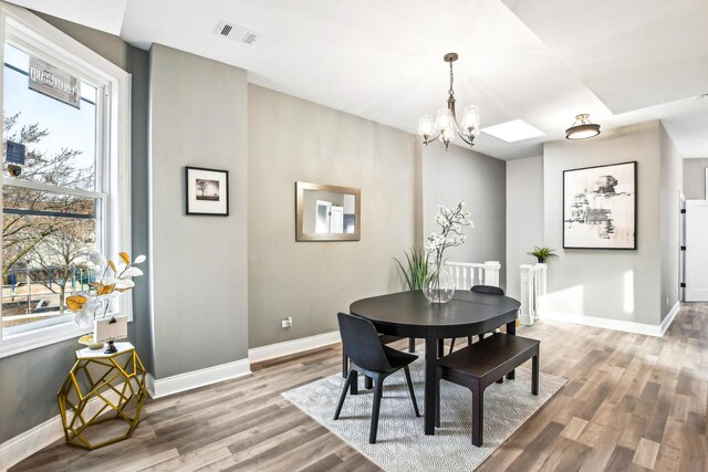 dining room featuring wood-type flooring and an inviting chandelier