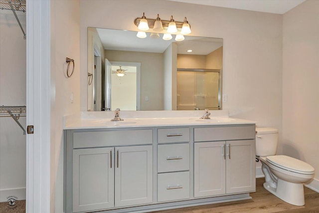 bathroom featuring vanity, a shower with door, ceiling fan, wood-type flooring, and toilet