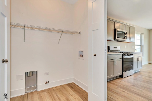 laundry area with hookup for a washing machine and light hardwood / wood-style flooring