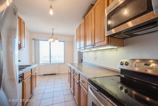 kitchen with radiator heating unit, stainless steel appliances, a notable chandelier, pendant lighting, and light tile patterned flooring