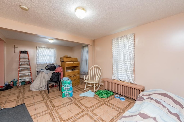 bedroom with a textured ceiling and radiator