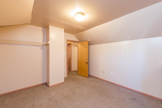 additional living space with carpet flooring and vaulted ceiling