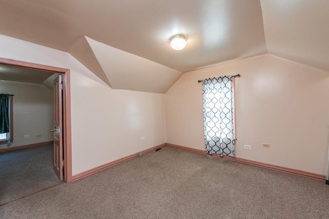 additional living space with carpet flooring and lofted ceiling