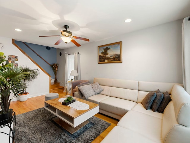 living room featuring hardwood / wood-style floors and ceiling fan