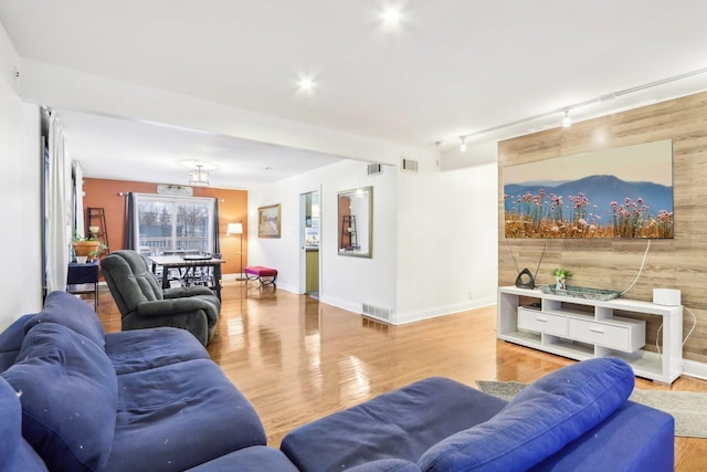 living room with rail lighting and light wood-type flooring