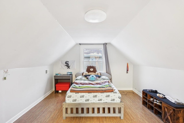 bedroom with wood-type flooring and vaulted ceiling