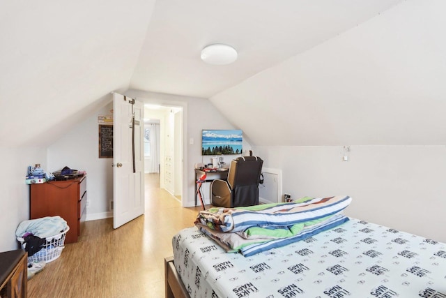 bedroom with lofted ceiling and light hardwood / wood-style floors