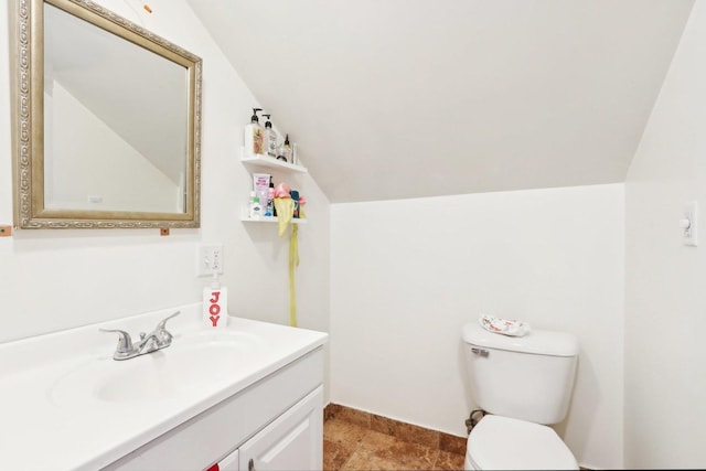 bathroom with lofted ceiling, vanity, and toilet