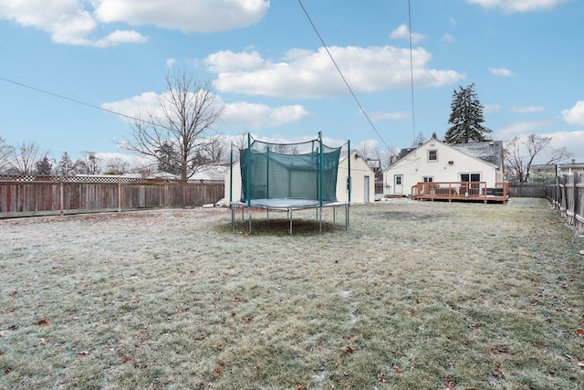 view of yard featuring a trampoline and a deck