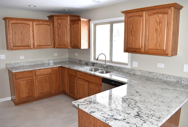 kitchen with stainless steel dishwasher, light stone countertops, and sink