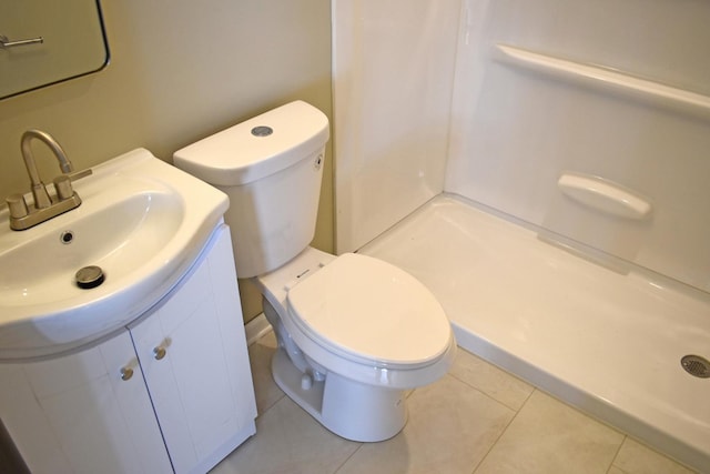 bathroom with toilet, a shower, vanity, and tile patterned floors