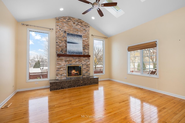 unfurnished living room with light wood-type flooring, lofted ceiling with skylight, and ceiling fan