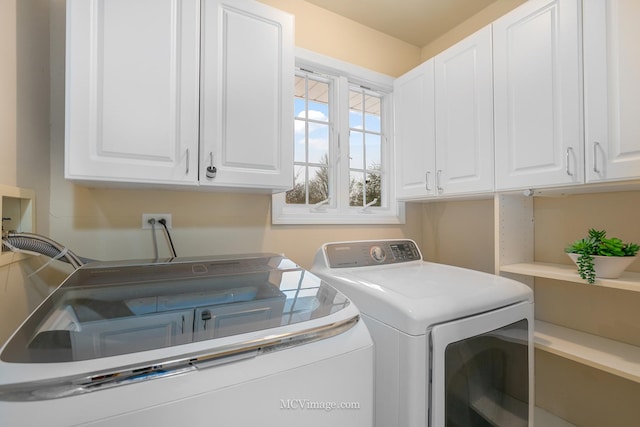 laundry area featuring washer and dryer and cabinets