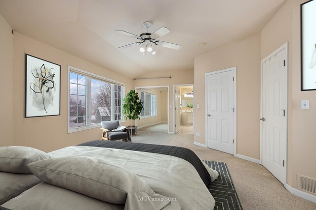 carpeted bedroom with connected bathroom, ceiling fan, and lofted ceiling