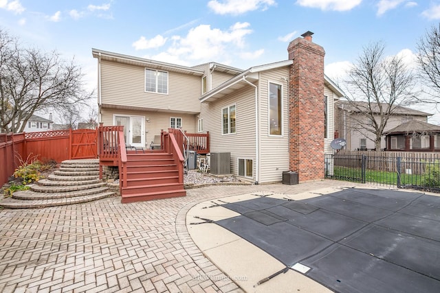 back of property with a patio area, a deck, and central AC