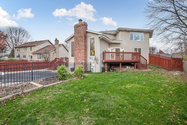 rear view of property with a lawn and a deck