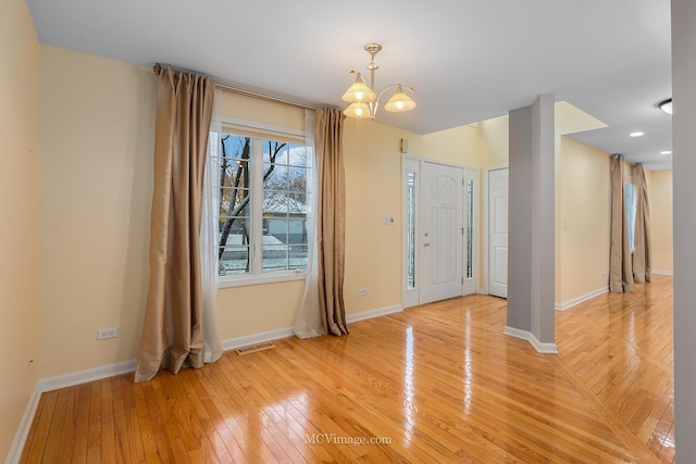 foyer entrance featuring hardwood / wood-style floors and a notable chandelier