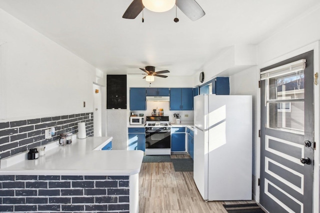 kitchen with blue cabinets, white appliances, kitchen peninsula, ceiling fan, and light hardwood / wood-style floors