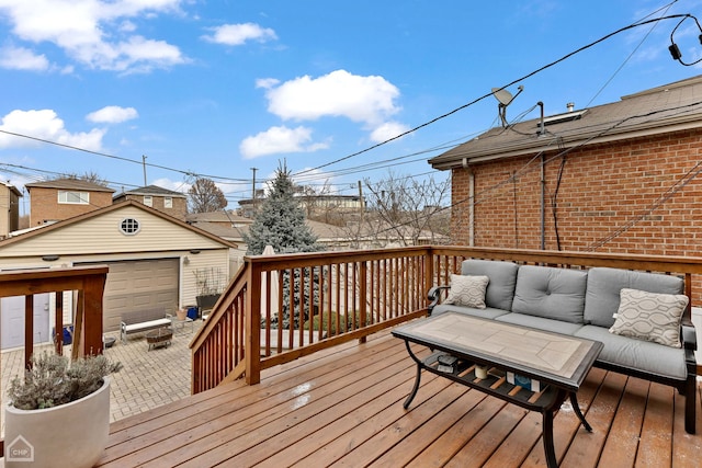 deck featuring a garage, an outdoor hangout area, an outdoor structure, and a patio