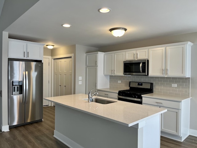 kitchen with sink, stainless steel appliances, backsplash, an island with sink, and white cabinets