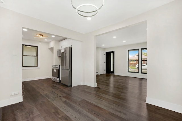 unfurnished living room with ceiling fan and dark wood-type flooring