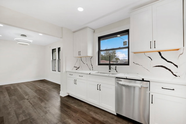 kitchen with white cabinets, dark hardwood / wood-style floors, stainless steel dishwasher, and sink