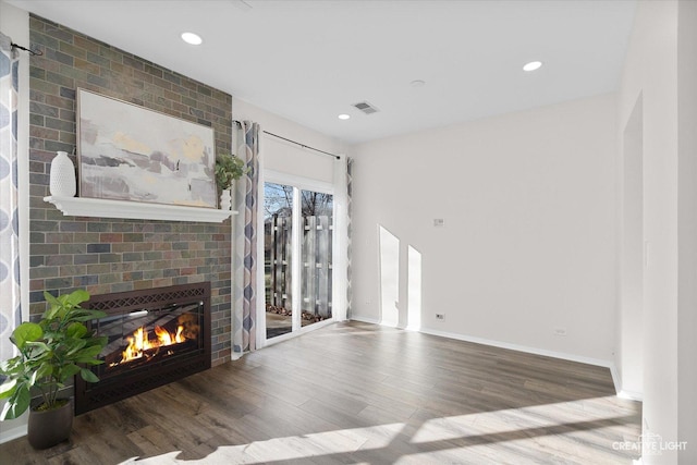 unfurnished living room featuring wood-type flooring and a fireplace