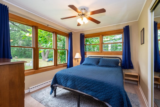 bedroom with multiple windows, ceiling fan, crown molding, and a baseboard radiator